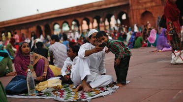 A Muslim boy looks at a mobile phone before having his iftar (breaking fast) meal during the holy month of Ramadan at the Jama Masjid (Grand Mosque) in the old quarters of Delhi August 1, 2013. Reuters
