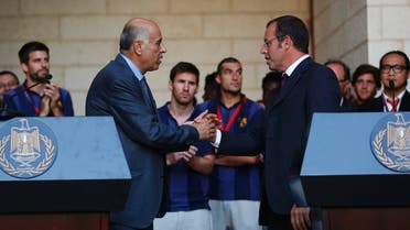 Barcelona President Sandro Rosell (R) and Palestinian Football Association President Jibril Rajoub shake hands after addressing members of the media at the start of a visit by the soccer team at the Palestinian President's office in the West Bank town of Bethlehem August 3, 2013. (Reuters)
