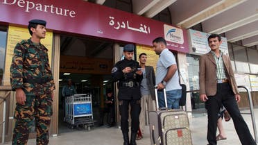 People present their documents before entering the departure lounge at Sanaa International Airport to leave Yemen on August 6, 2013.