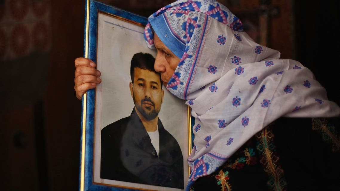 The mother of Palestinian Salah al-Shaer, who has been held by Israel for 20 years, kisses his picture after hearing news on the expected release of her son on August 12, 2013. (Reuters)