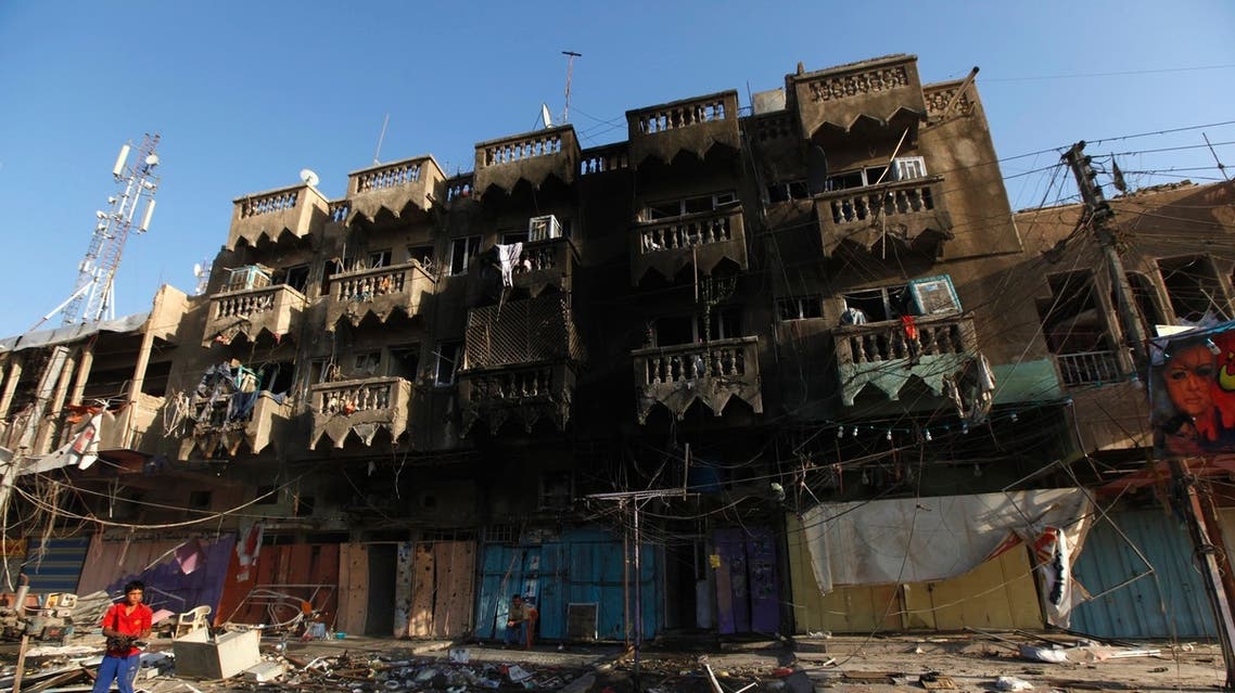 A boy looks at the site of a car bomb attack in the Shaab neighbourhood of northern Baghdad August 11, 2013.