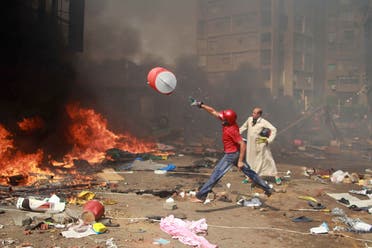 A supporter of the Muslim Brotherhood and Egypt's ousted president Mohamed Morsi throws a water container onto a fire during clashes with police in Cairo. (AFP)