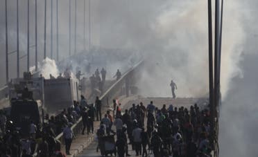 Members of the Muslim Brotherhood flee from tear gas and rubber bullets fired by riot police during clashes, on a bridge leading to Rabba el Adwia Square where they are camping, in Cairo August 14, 2013. (Reuters)