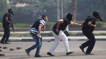 Riot police officers run during clashes with members of the Muslim Brotherhood and supporters of deposed Egyptian President Mohamed Mursi