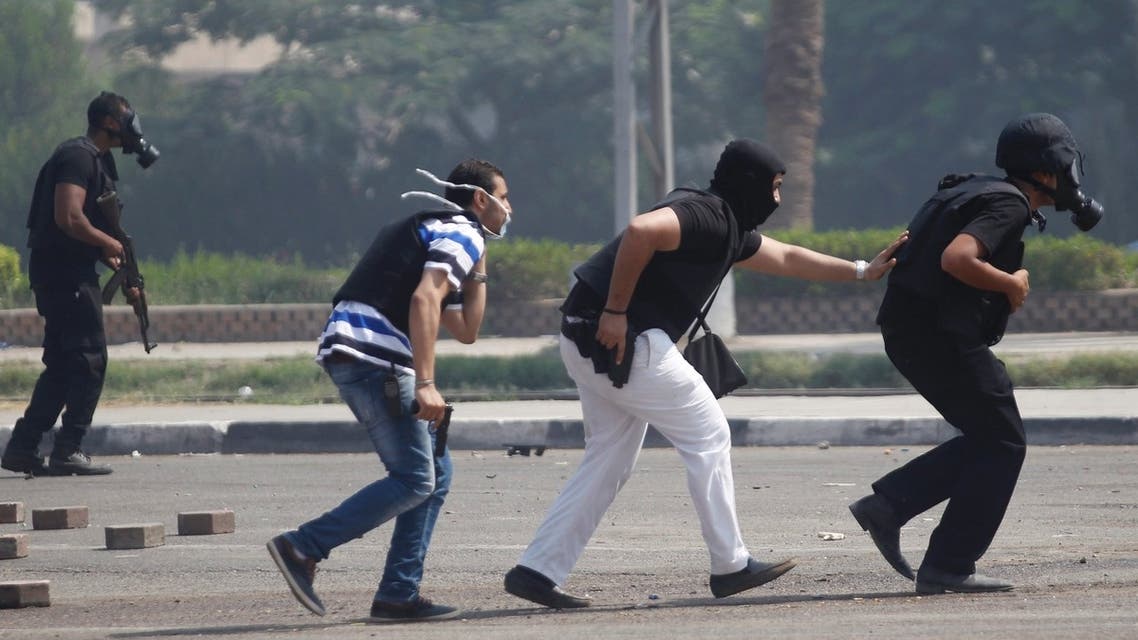 Riot police officers run during clashes with members of the Muslim Brotherhood and supporters of deposed Egyptian President Mohamed Mursi
