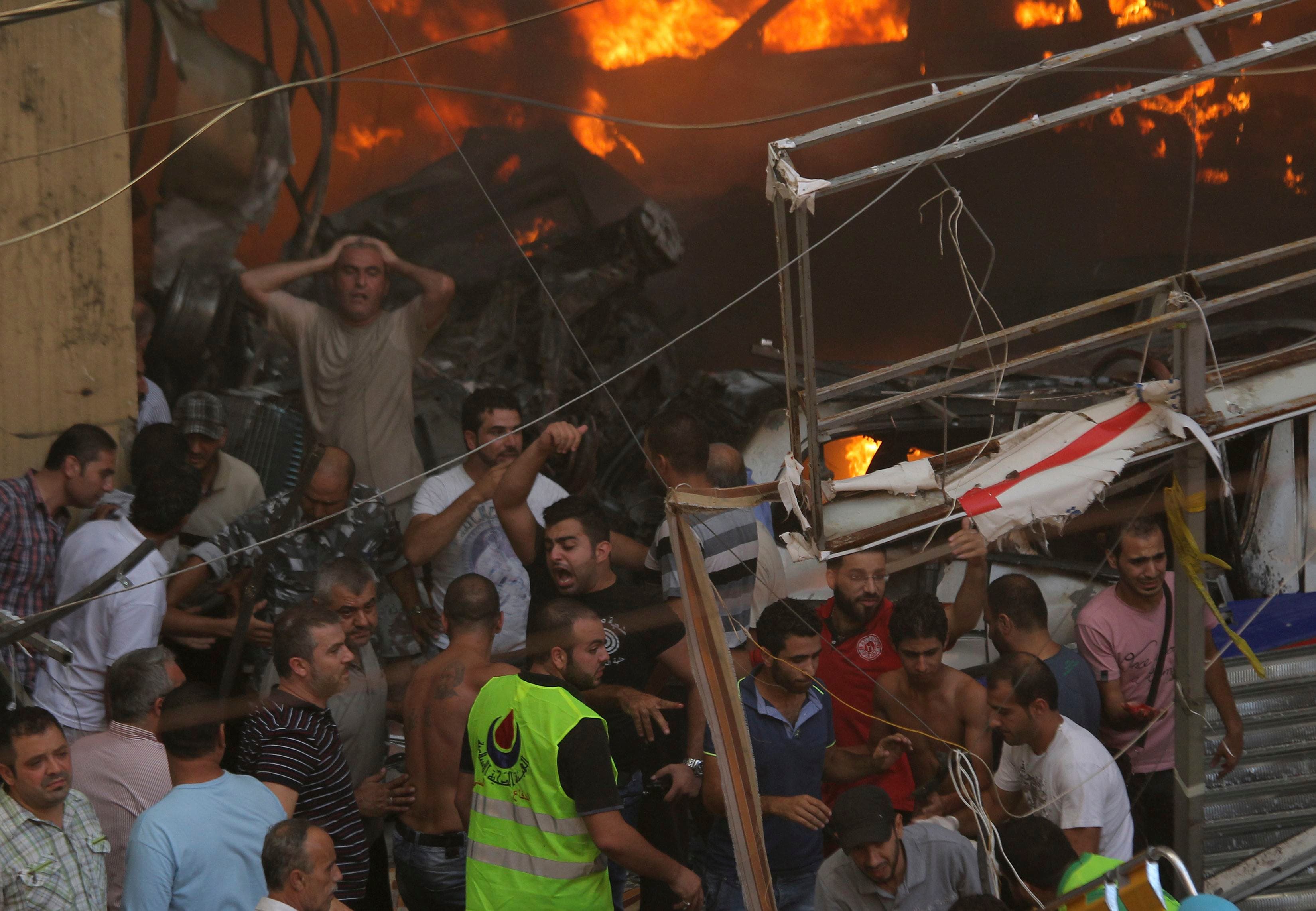 People react as they gather around the site of an explosion in Beirut's southern suburbs, August 15, 2013. (Reuters)
