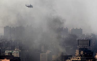 A military helicopter flies over clouds of smoke after clashes between members of the Muslim Brotherhood and supporters of ousted Egyptian President Mohamed Mursi at Azbkya police station during clashes at Ramses Square in Cairo, August 16, 2013. (AFP)