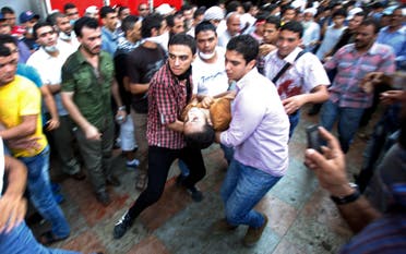 Supporters of deposed Egyptian President Mohamed Mursi carry an injured demonstrator who was shot during clashes in front Azbkya police station at Ramses Square in Cairo, August 16, 2013. (Reuters)