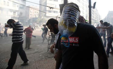 A member of the Muslim Brotherhood and supporter of ousted Egyptian President Mohamed Mursi wears a makeshift gas mask as others run away from shooting during clashes in front of Azbkya police station during clashes at Ramses Square in Cairo August 16, 2013. (Reuters)