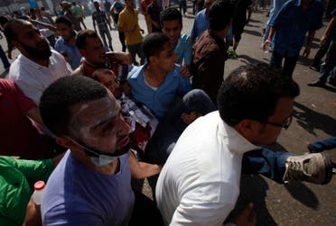 Supporters of deposed Egyptian President Mohamed Mursi carry an injured demonstrator who was shot during clashes in front Azbkya police station at Ramses Square in Cairo, August 16, 2013. (AFP)