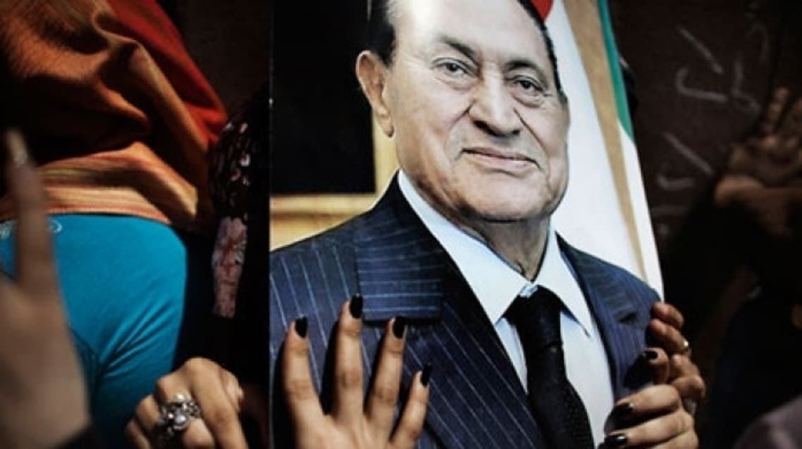 Hosni Mubarak supporters hold up his picture during his trial. Photograph: Marco Longari/AFP/Getty Images