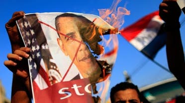 Opponents of Egypt's deposed President Mohamed Mursi burn pictures of U.S. President Barack Obama at a rally in Cairo on July 7
