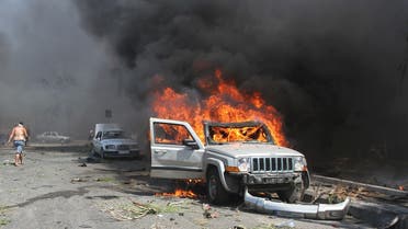 A car burns outside one of two mosques hit by explosions in Lebanon's northern city of Tripoli, August 23, 2013.