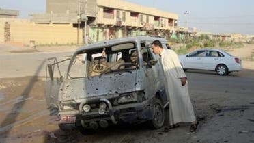 A resident inspects a damaged vehicle a day after a car bomb attack in Dujail, 50 km (31 miles) north of Baghdad, August 23, 2013. (Reuters)