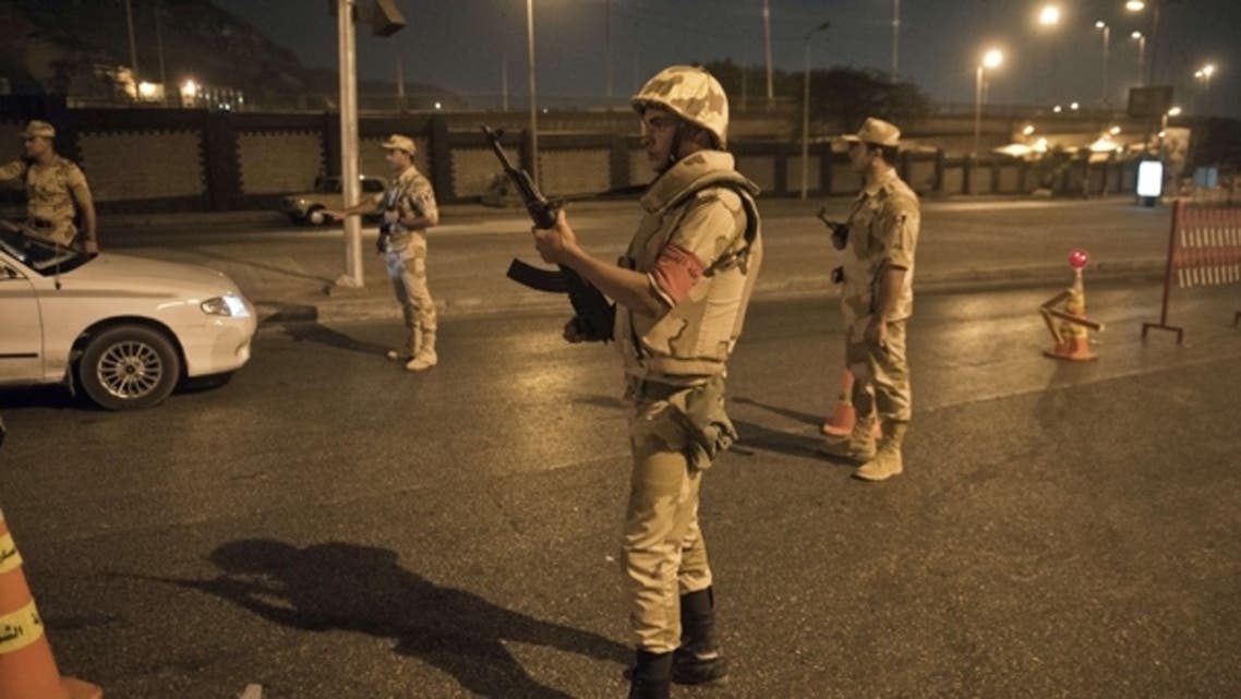 Egyptian troops keep watch at a checkpoint during the curfew hours in Cairo late on August 19, 2013. (AFP)