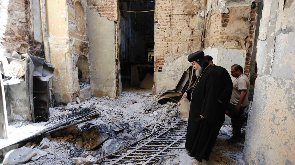 Bishop-General Macarius, a Coptic Orthodox leader, walks around the burnt and damaged Evangelical Church in Minya governorate, about 245 km (152 miles) south of Cairo, August 26, 2013. (Reuters)