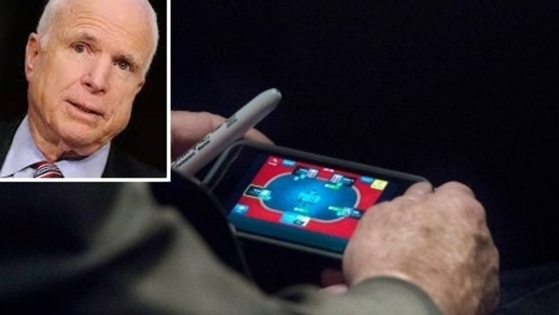 McCain was snapped playing poker on his smartphone. (Washington Post)