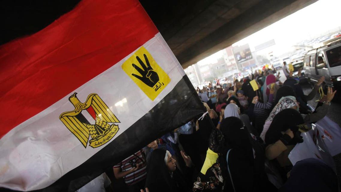 Members of the Muslim Brotherhood and supporters of ousted Egyptian President Mohamed Mursi hold the national flag bearing the "Rabaa" or "four" label, as they protest against the military and interior ministry in the southern suburb of Maadi September 3, 2013. (Reuters)