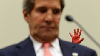 Red-stained hands wave in protest at U.S. hearing on Syria  