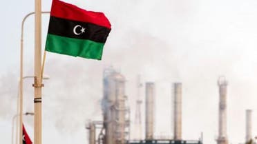 The Libyan flag flutters outside an oil refinery in Zawiya. (File photo: AFP)