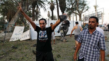  Libyan man shows a dead bird flashing the sign of victory outside a foreign ministry building that was damaged by a powerful blast on September 11, 2013 in the eastern Libyan city of Benghazi. afp