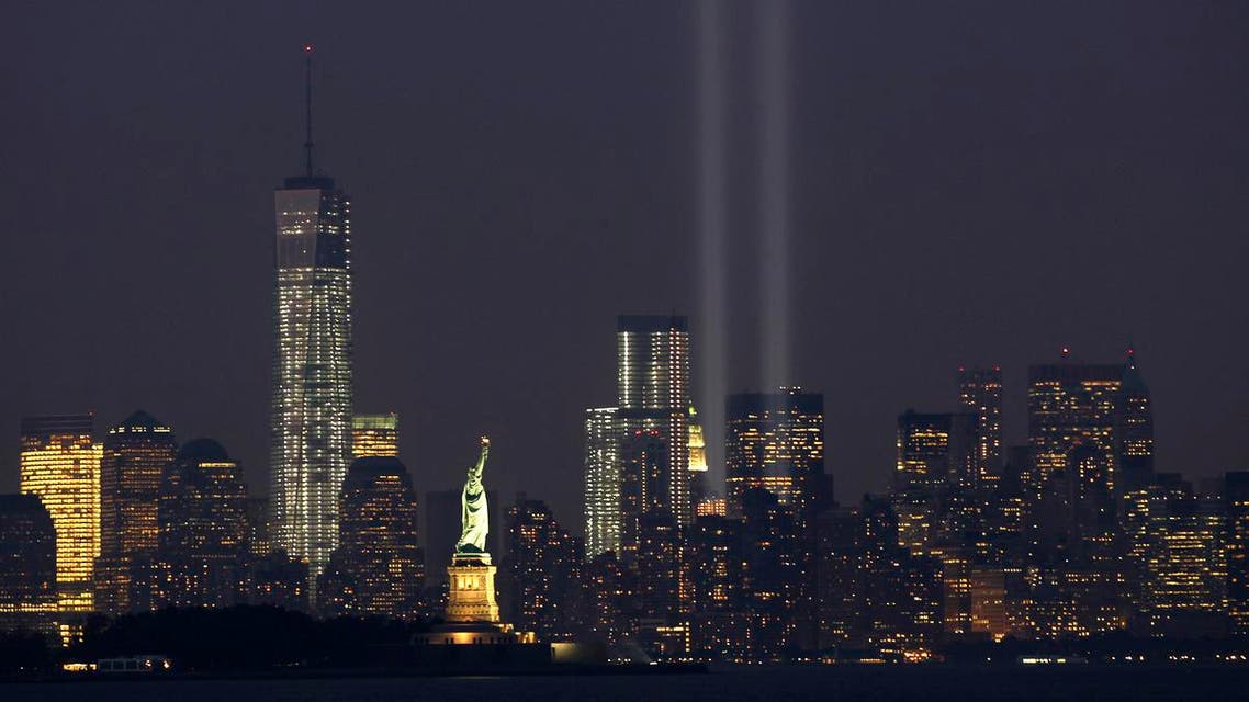 The Tribute in Light is illuminated next to the Statue of Liberty (C) and One World Trade Center (L) during events marking the 12th anniversary of the 9/11 attacks on the World Trade Center in New York, September 10, 2013.