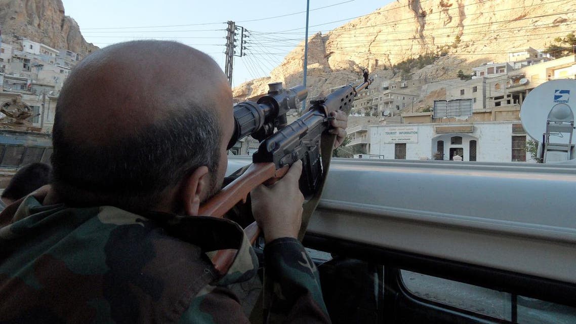 A Syrian pro-government soldier aims his rifle as he patrols the streets of the Christian town of Maalula on September 11, 2013. (AFP)