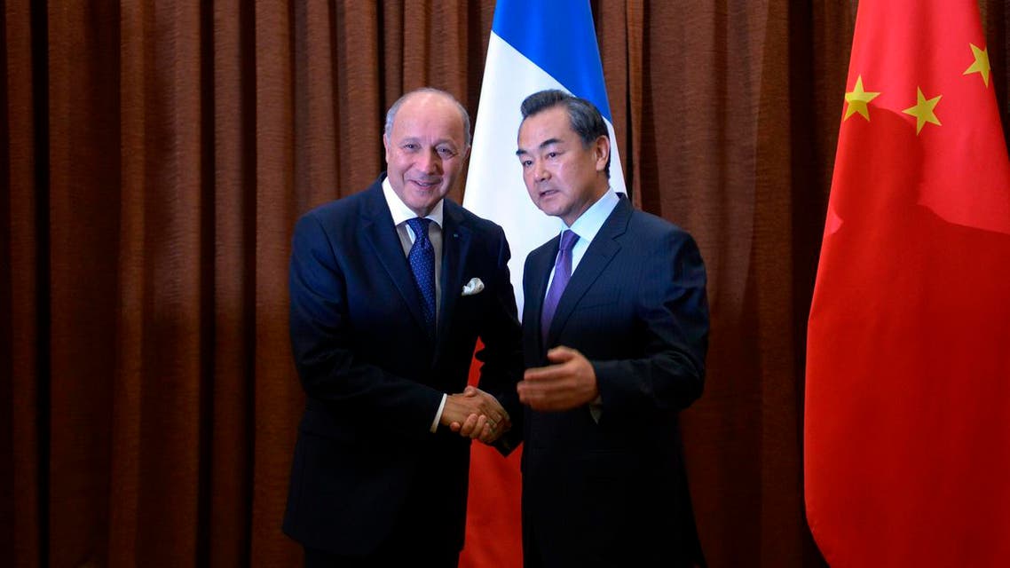 French Foreign Minister Laurent Fabius (L) shakes hands with Chinese Foreign Minister Wang Yi before their meeting at the Chinese Foreign Ministry in Beijing, September 15, 2013. (Reuters)