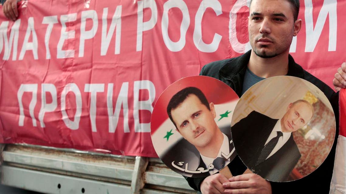 A participant hold images of Russian President Vladimir Putin and Syrian President Bashar al-Assad during an anti-war protest organised by the Communist party near the U.S. embassy in Moscow September 12, 2013. (Reuters)