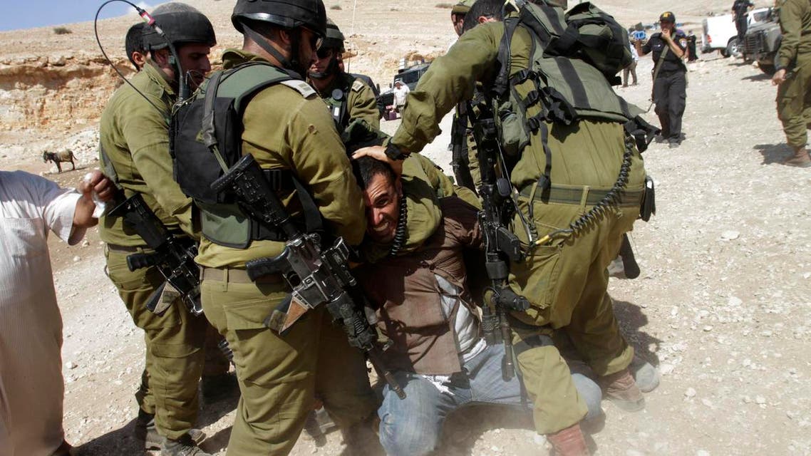 Israeli soldiers detain a Palestinian during scuffles following an attempt by European diplomats to deliver goods to locals in the West Bank herding community of Khirbet al-Makhul, in the Jordan Valley Sept. 20, 2013. (Reuters)