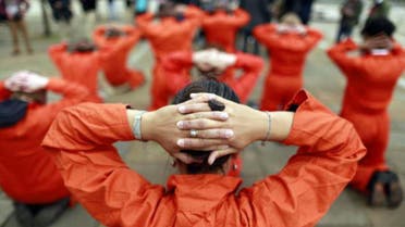 Activists from Amnesty International dressed as Guantanamo Bay detainees take part in a photo call in front of the Waterfront Hall in Belfast June 16, 2013,  rey