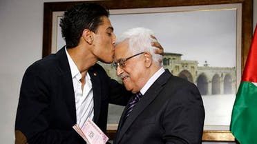 "Arab Idol" Mohammed Assaf kisses Palestinian President Mahmoud Abbas as he hands him a diplomatic Palestinian Authority passport during their meeting in the West Bank city of Ramallah, July 1, 2013.   reu