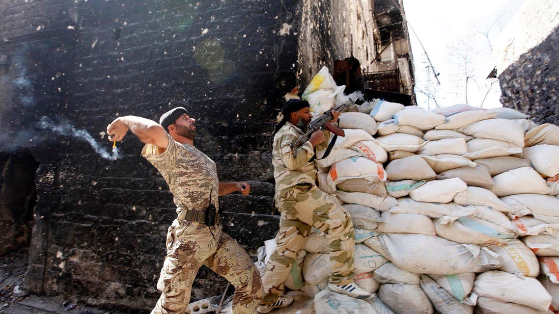 A Free Syrian Army fighter throws a homemade bomb towards the Justice Palace, which is controlled by forces loyal to Syria's President Bashar al-Assad, in Aleppo Oct.4, 2013. (Reuters)