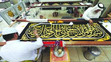 Saudi worker sew Islamic calligraphy in gold thread on a drape to cover the Kaaba at the Kiswa factory in the holy city of Mecca afp