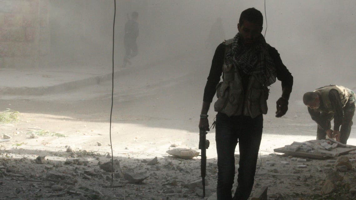 A Free Syrian Army fighter holds his weapon as he walks during what activists said was shelling by forces loyal to Syria's President Bashar al-Assad in an Aleppo district October 10, 2013. (Reuters)