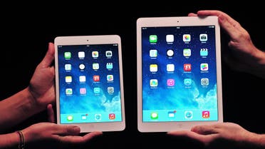 Apple employees show off the new iPad Air (R) and iPad Mini at a satellite launch event in central London on Oct. 22, 2013. (AFP)