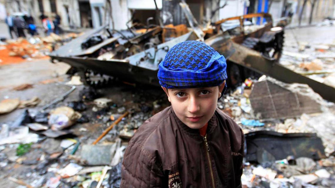 A Syrian boy stands in front of a damaged armored vehicle belonging to the Syrian army in a street. (File photo: Reuters)