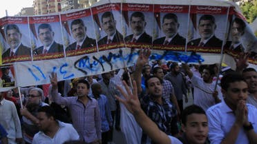 Supporters of the Muslim Brotherhood and ousted Egyptian President Mohammad Mursi shout slogans against the military and interior ministry, under Mursi posters, during a protest near Giza square on October 25, 2013. (Reuters)