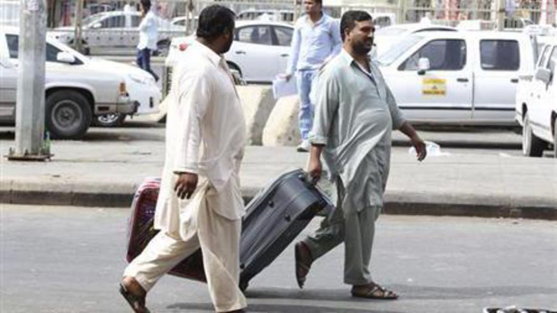 Foreign workers pull their luggage along a street in Riyadh November 4, 2013. reuters