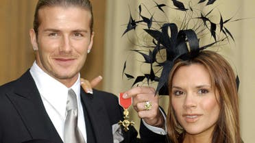 David Beckham, seen with his wife Victoria, collecting his OBE in 2003. (Reuters) 