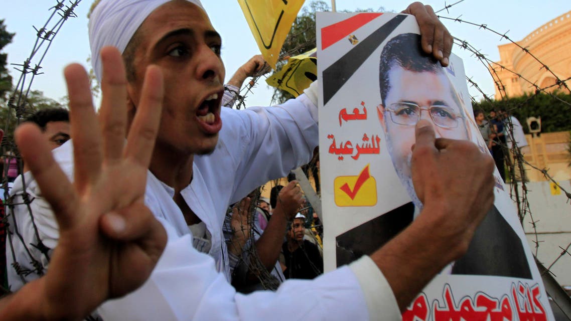 Supporters of the Muslim Brotherhood and ousted Egyptian President Mohammad Mursi shout slogans against the military and interior ministry, while gesturing with four fingers, during a protest in Cairo, November 15, 2013.