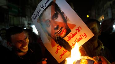 In this Wednesday, Oct. 30, 2013 photo, Supporters of army chief Gen. Abdel-Fattah al-Sisi burn a poster with a photo of Bassem Youssef. (AP)