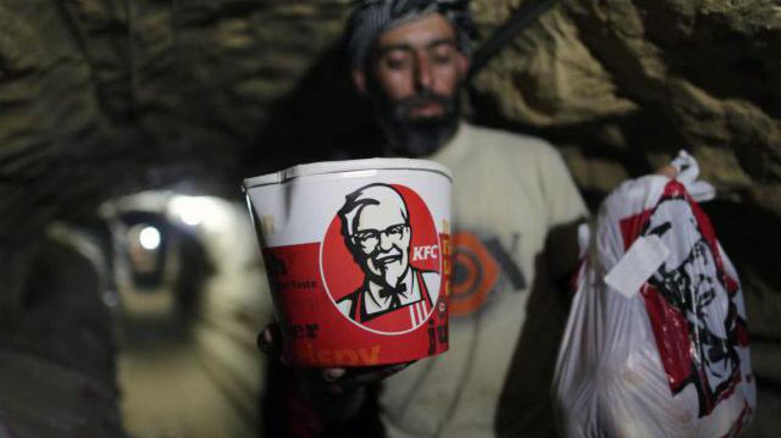 A smuggler carries food from Kentucky Fried Chicken through an underground tunnel linking the Gaza Strip to Egypt, on May 13, 2013 in Rafah. (File photo: AFP)