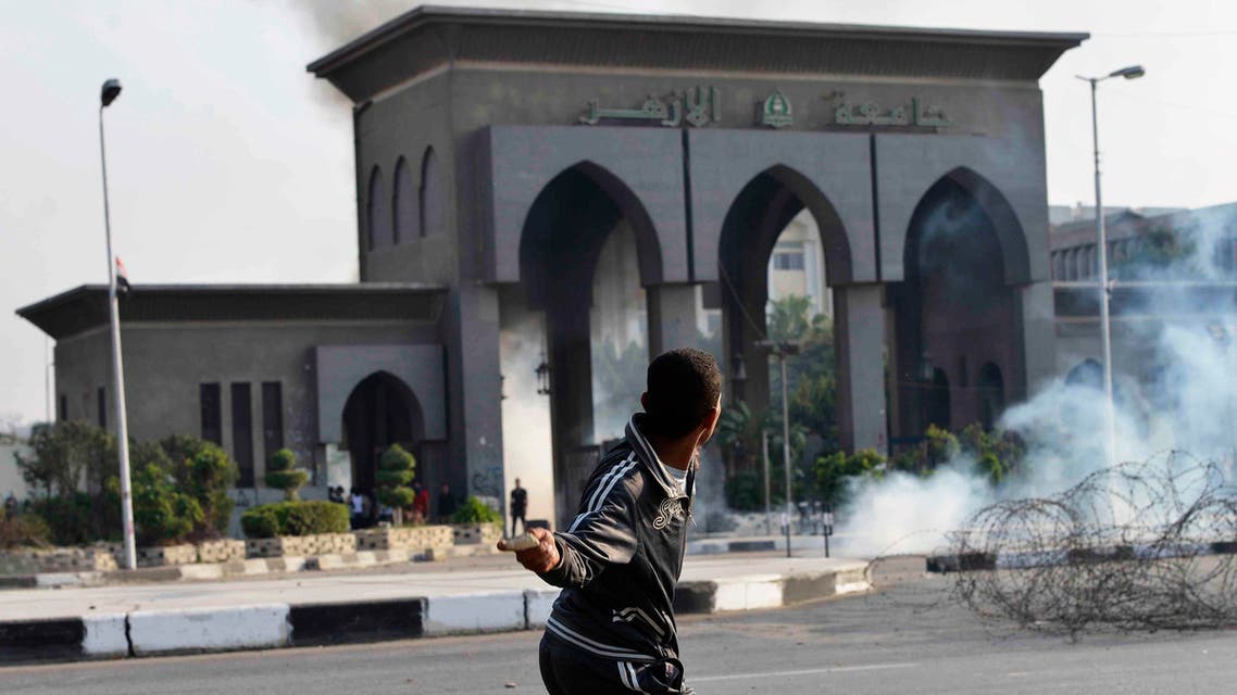 A man throws a stone in front of Al-Azhar University student members of the Muslim Brotherhood and supporters of ousted Egyptian President Mohamed Mursi, as riot police fired tear gas to stop them marching towards Rabaa al-Adaweya square, in Cairo October 28, 2013. reuters