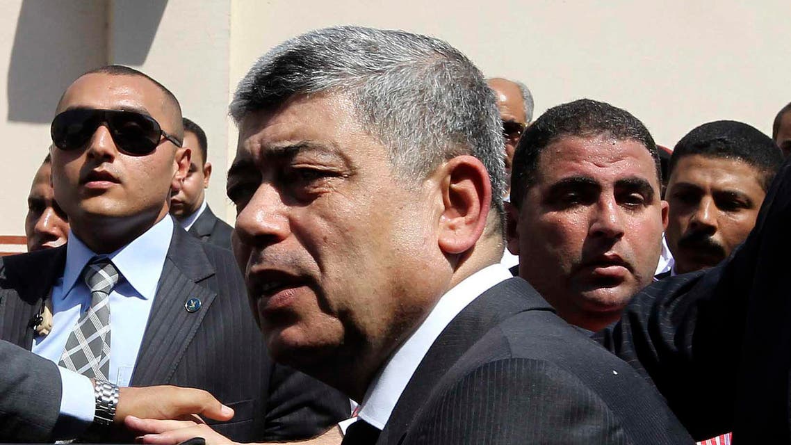 Egypt's Interior Minister Mohamed Ibrahim (C) gets into his car after attending the funerals of policemen killed during clashes in Cairo, Aug. 15, 2013. (Reuters)