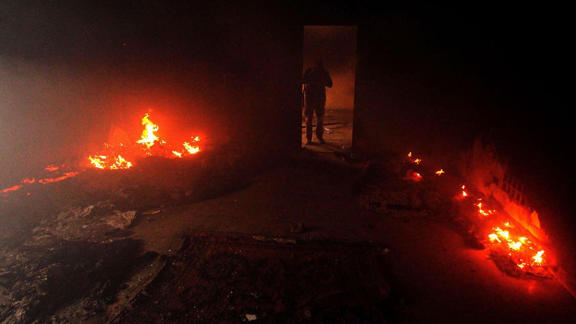 A Libyan man stands in a building used by Ansar al-Sharia militia after it was torched by residents on November 25, 2013 in Benghazi.