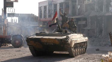 Soldiers loyal to the Syrian regime gesture while on their military tanks in Qusair. Syrian troops stormed Deir Attiyeh and has killed scores of civilians, opposition activists said. (File photo: Reuters)