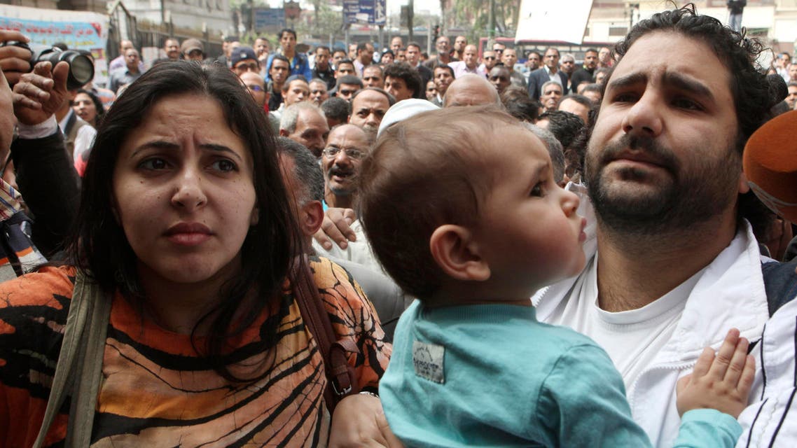 A file photo shows Alaa Abdel Fattah (R) arrives with his wife and child to the public prosecutor's office in Cairo, March 26, 2013. (Reuters)