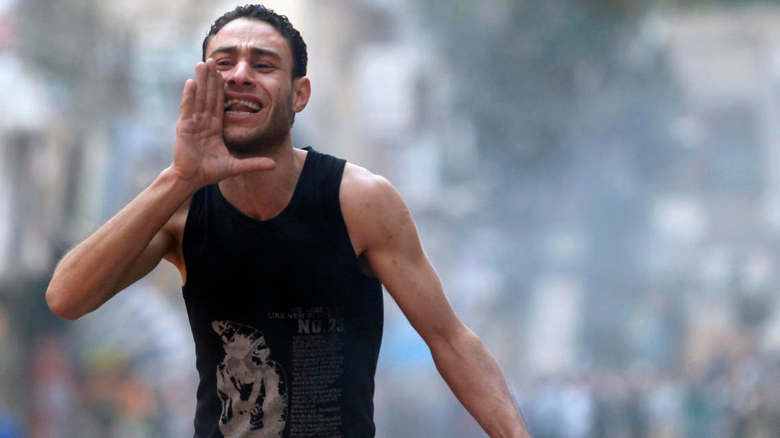 A supporter of the Muslim Brotherhood and ousted Egyptian President Mohamed Mursi shouts slogans in front of tear gas fired by riot police and army, during clashes at el-Talbyia near Giza square, south of Cairo, Nov. 29, 2013. (Reuters)