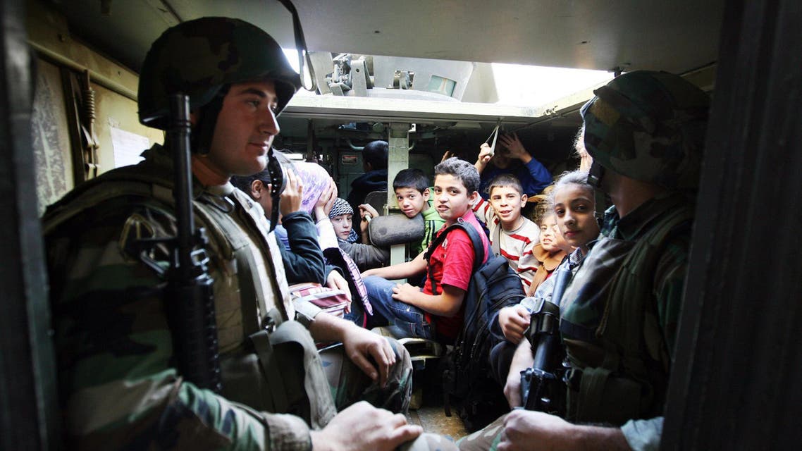 Lebanese army soldiers evacuate civilians caught in sniper fire in the Lebanese northern coastal city of Tripoli on Nov. 30, 2013. (Reuters)